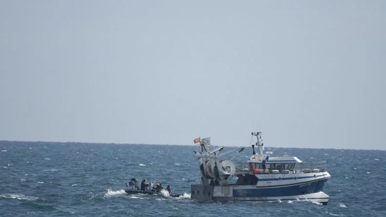 Une équipe de contrôle s'approche d'un chalutier