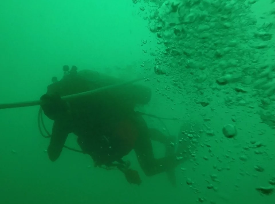 Un plongeur-démineur descend le long de la ligne de vie