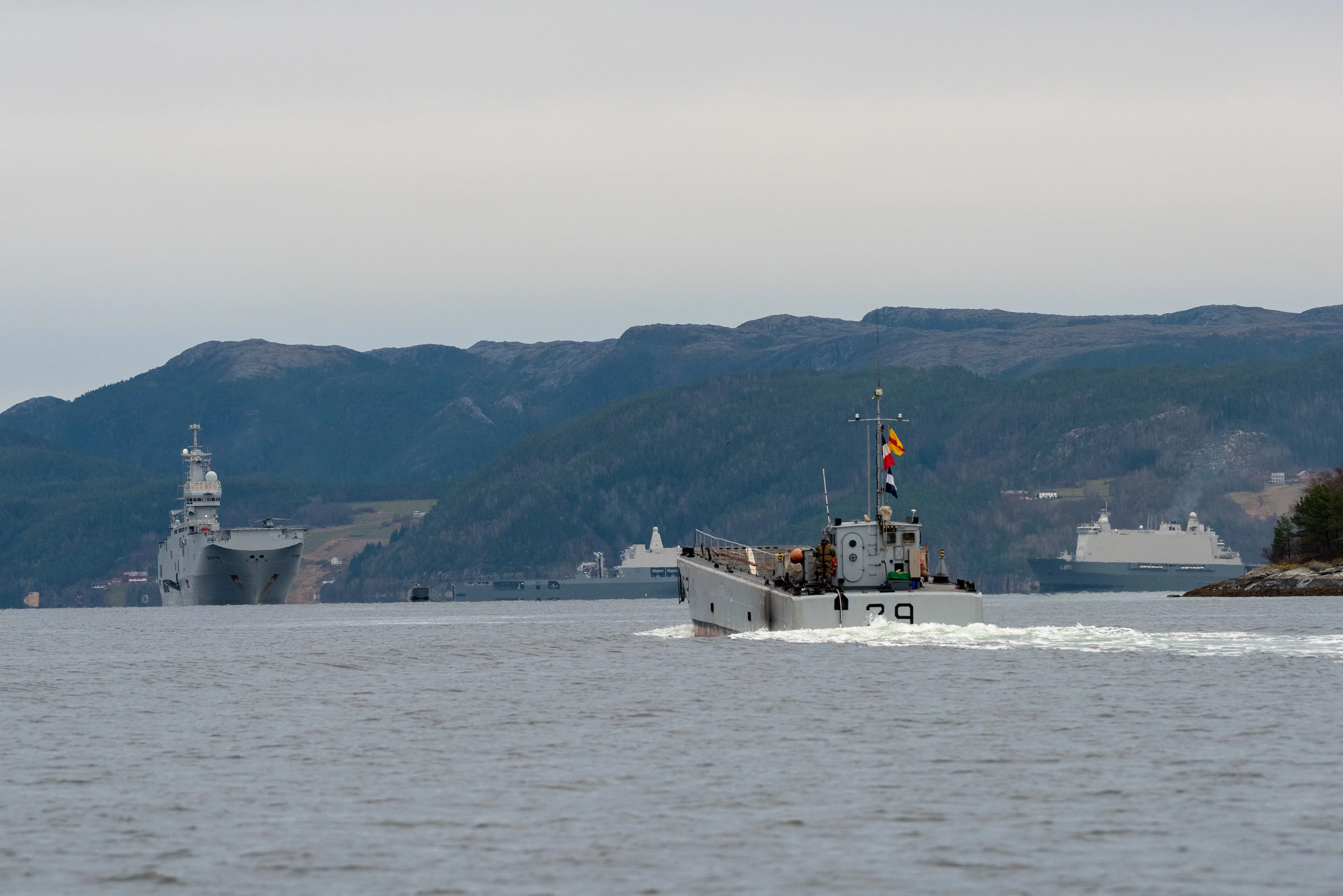 Un chaland de transport de matériel se dirige vers le BPC Dixmude