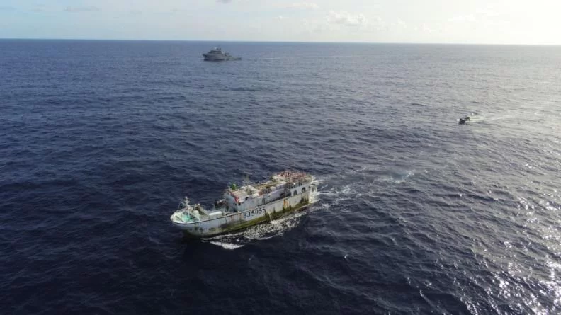 Le bâtiment de soutien Bougainville et un bateau de pêche
