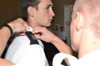 Un élève en première année d’études supérieures au Lycée Naval reçoit d'un de ses ainés le manchon « Flotte Guépratte »