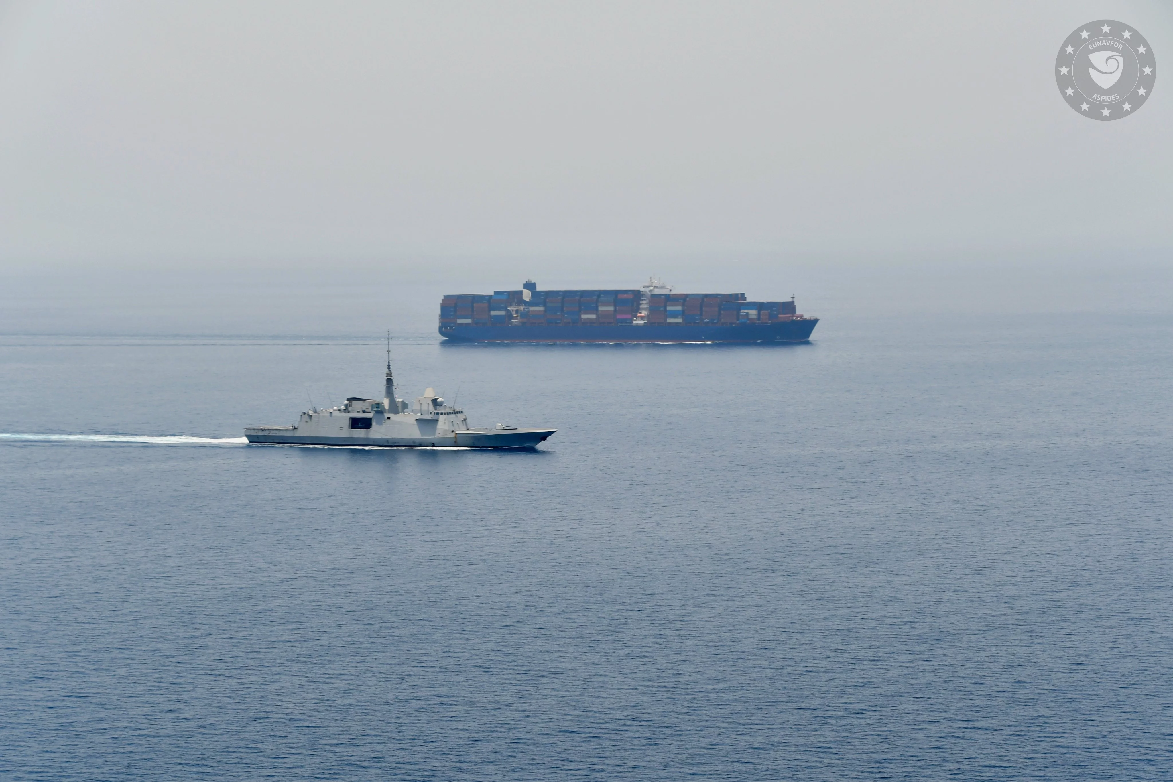 Une frégate multi-missions escorte un port-econteneurs dans le détroit de Bab-el-Manded