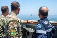 Le Commodore Philip Dennis, Royal Navy; le vice-amiral Emmanuel Slaars, Alindien et le vice-amiral Brad Cooper, US Navy, observent une embarcation des gardiens de la Révolution iranienne lors d'un transit dans le détroit d'Ormuz