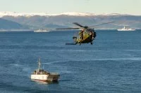Un hélicoptère survole un chaland de transport de matériel