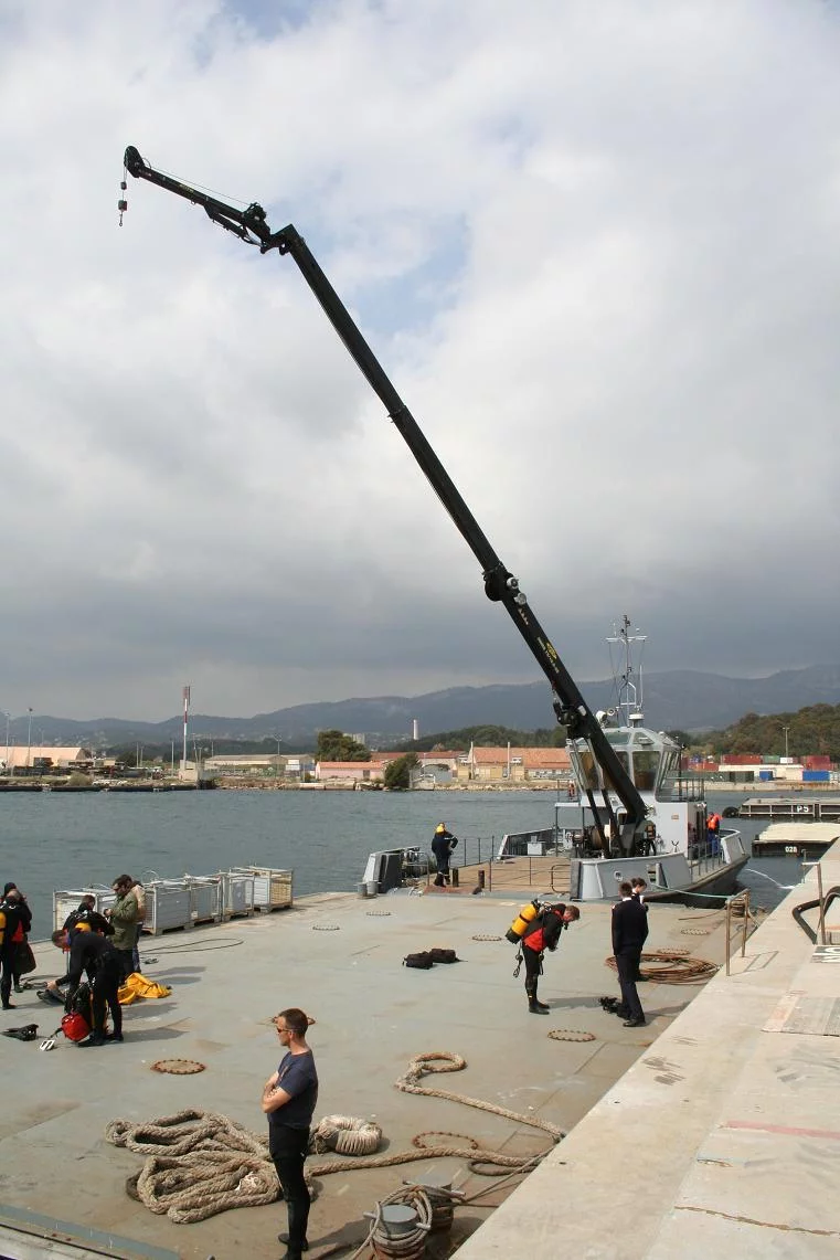 Une grue flottante permet de remonter les déchets rassemblés par les plongeurs