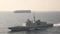 Une frégate escorte un porte-conteneurs en mer Rouge