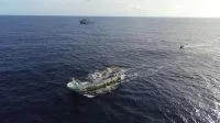 Le bâtiment de soutien Bougainville et un bateau de pêche