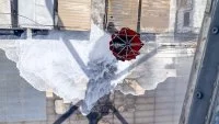 Un hélicoptère largue de l'eau sur la coque de l'USS Bonhomme Richard pour la refroidir