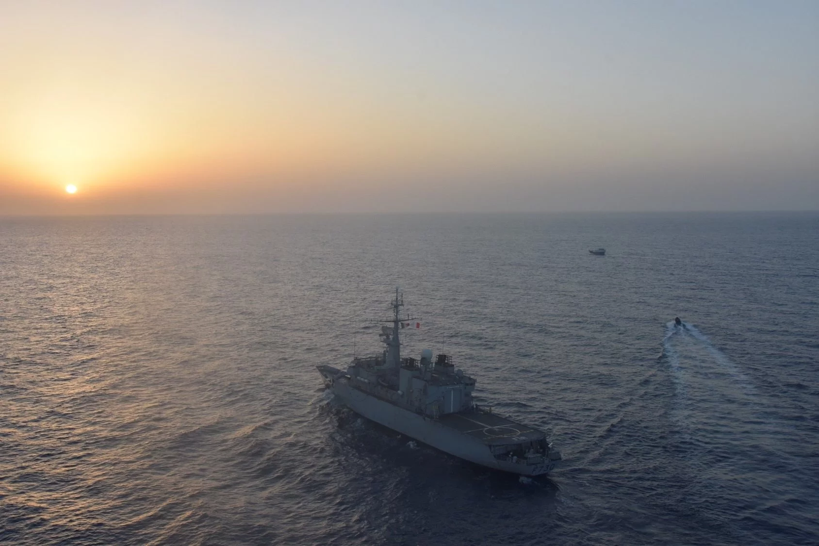 Une frégate de surveillance, dont l'équipe de visite va inspecter un boutre suspect